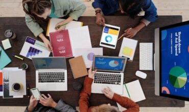 Coworkers with laptops working out an international market entry strategy